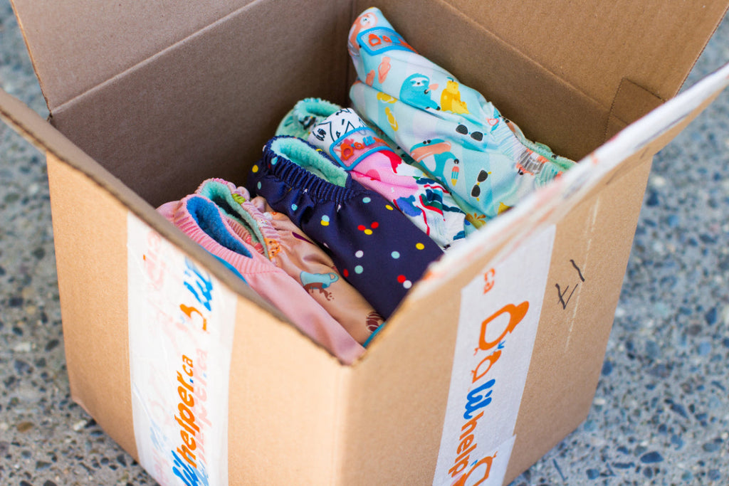 Box of colorful prints with a visible Lil Helper brand label 