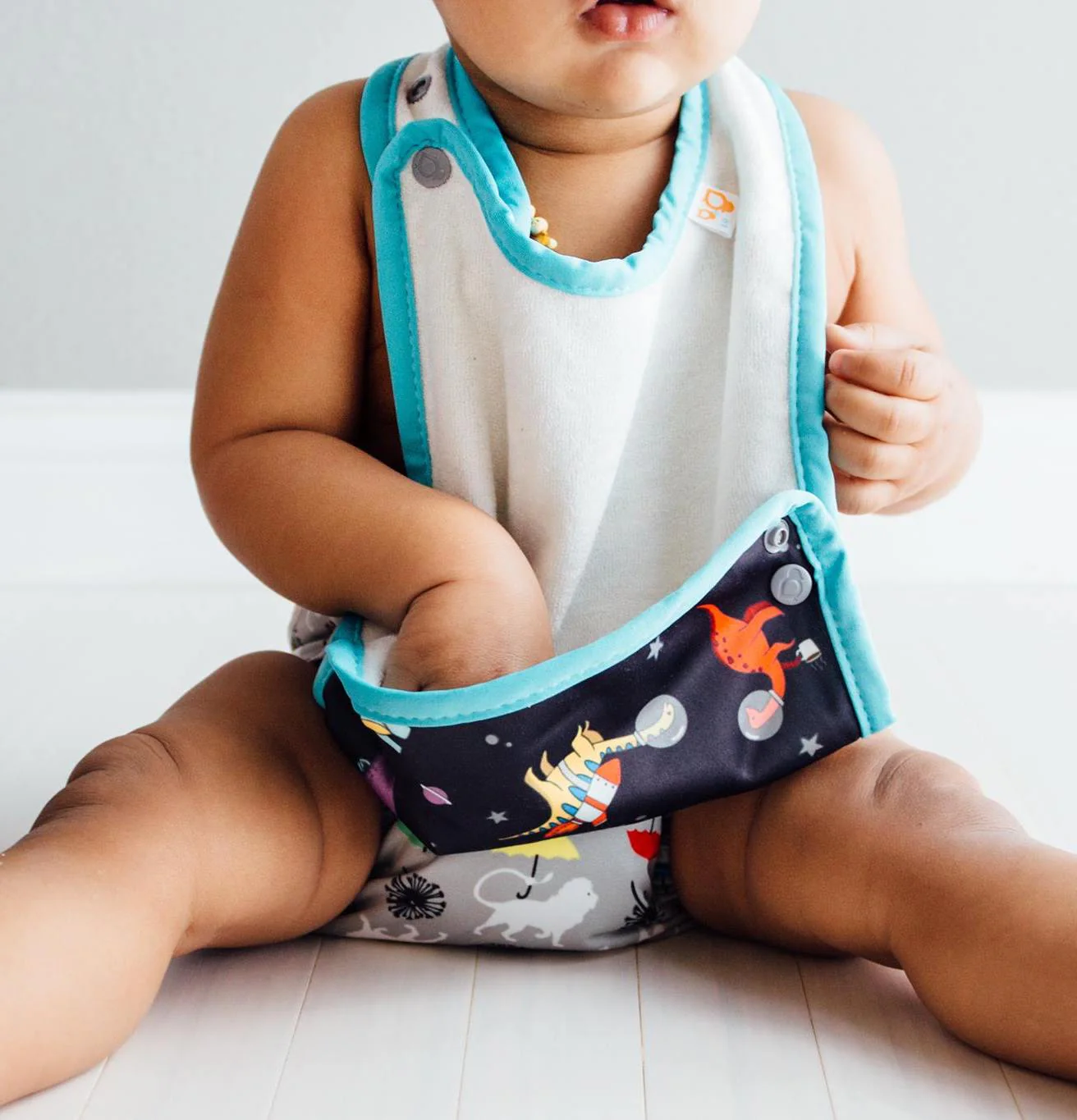 a child eating a snack from a baby cloth bib